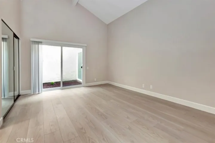 Cathedral ceiling, primary bedroom, sliding door to atrium (more natural light) two mirrored wardrobe closet doors