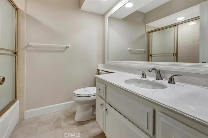 Hall bathroom, fresh counter, framed mirror, custom enclosure for shower over tub