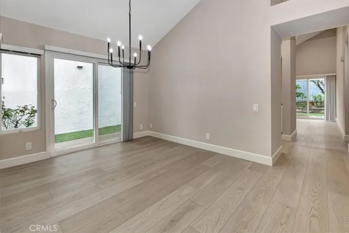 View dining room and slider to side yard, on right is hall to kitchen and family room beyond