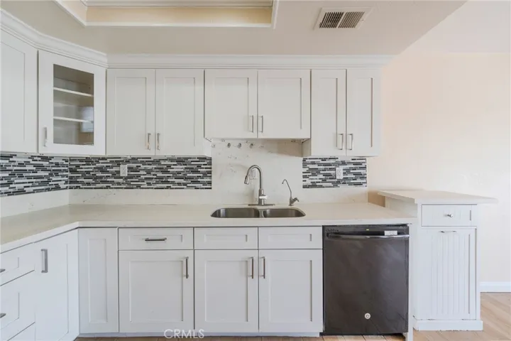 Spacious kitchen featuring an expansive countertop and a large, decorative backsplash.