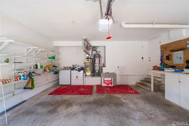 A large 2-car garage with laundry facilities, including a workbench and pre-installed shelves
