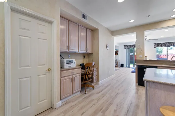 Integrated workspace featuring upper and lower cabinetry with a built-in desk