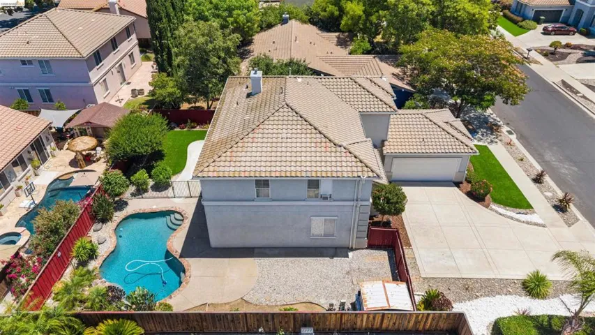 Two-story residence featuring a tile roof, an integrated two-car garage, and a concrete driveway