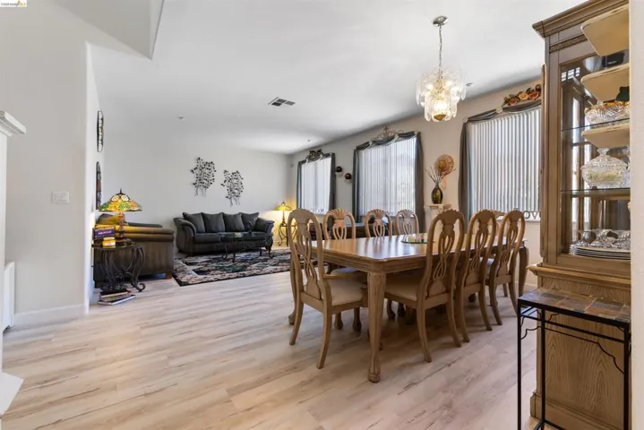 Spacious interior featuring light wood-finish flooring throughout the dining and living areas