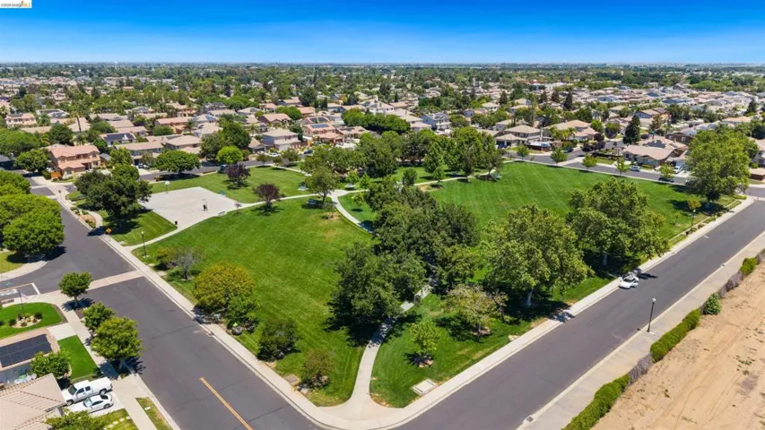 Aerial perspective showcasing a community green space with manicured lawns and mature trees
