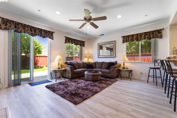 Living area featuring light wood-finish flooring and recessed lighting