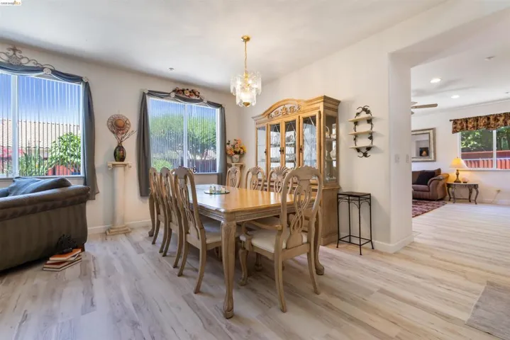 Dining area featuring wood-finish flooring, two window openings, recessed lighting, and an archway opening to an additional room