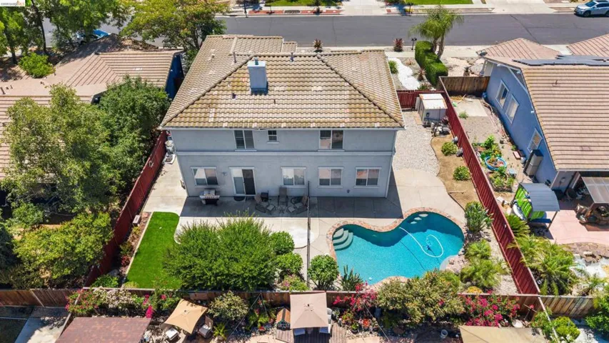 Two-story residence featuring a tile roof and a backyard swimming pool