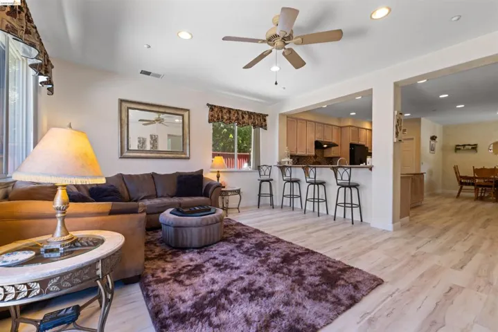 Open-concept living area featuring light wood-finish flooring, recessed lighting, and a ceiling fan