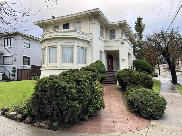 Stucco exterior with ornate architectural details, a prominent bay window, and a covered entry