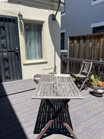 Private outdoor patio space featuring a weathered wood deck and a tall privacy fence
