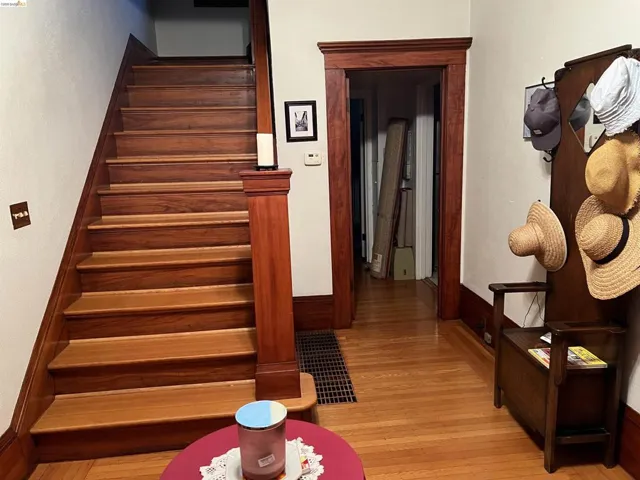 Hardwood staircase and flooring with detailed wood trim and doorway