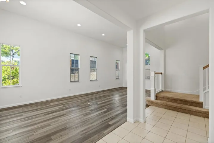 Vaulted ceilings with recessed lighting complement the wood-finish flooring in this open living space