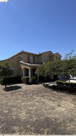 Stucco exterior with a tile roof and columned entryway