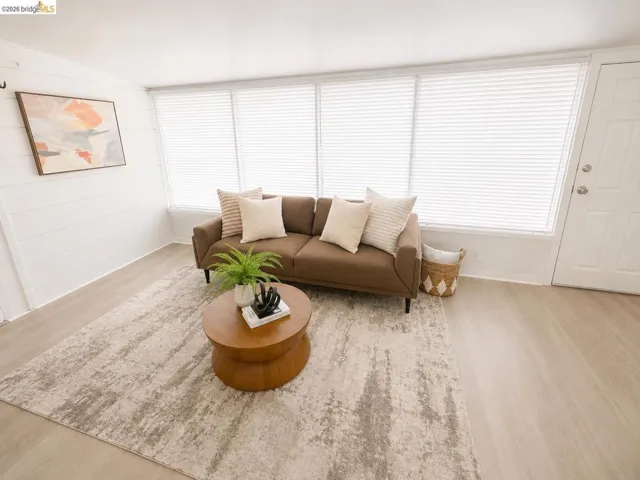 Living space featuring light wood-finish flooring and a white shiplap accent wall