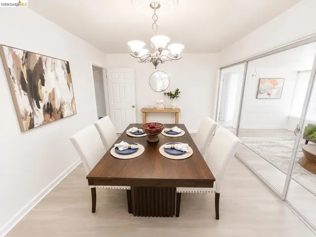 Formal dining space featuring light wood-finish flooring and a contemporary chandelier