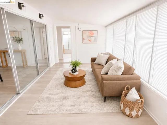 Bright sunroom featuring light wood-finish flooring and a white shiplap accent wall