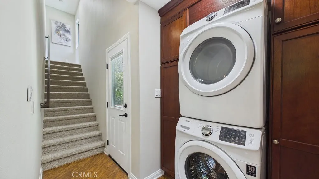 Laundry area featuring a side door access to the pool area and stairs leading to the upstairs bedroom with en-suite bath.