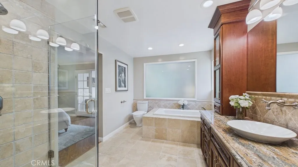 View of primary bathroom with separate shower and soaking tub.