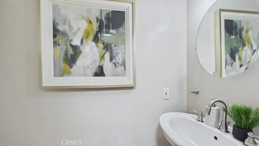 Powder room situated near the butler's pantry, adjacent to the laundry area and the side entrance leading to the backyard, with access to the staircase connecting to the bedroom above the garage.