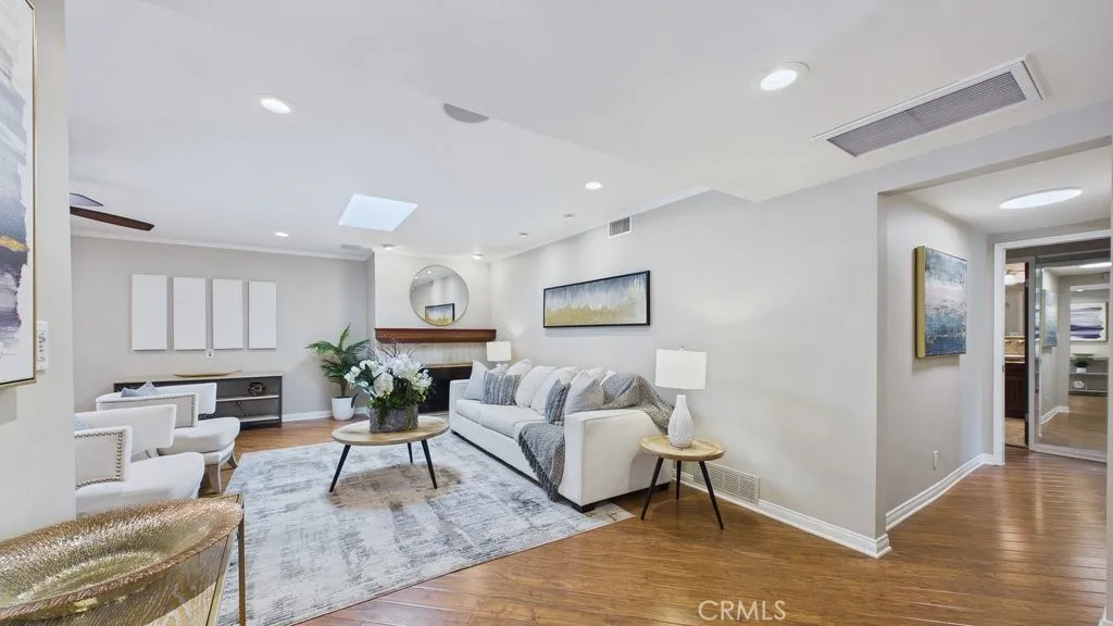View of living room with fireplace and hallway on the Right leading to the bedrooms, as seen from the main entry.