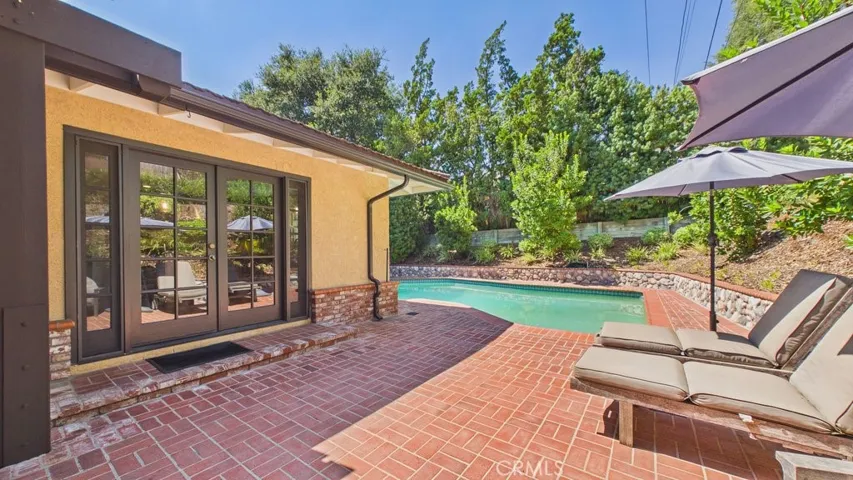 Spacious patio and pool area featuring French doors that provide direct access to the kitchen.