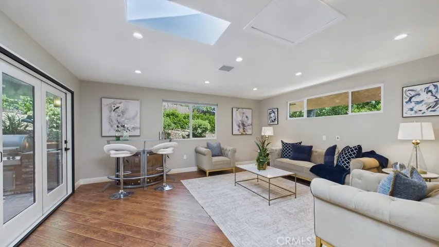 Spacious family room featuring an open-concept layout with seamless access to the patio and swimming pool area as seen from the primary bedroom.