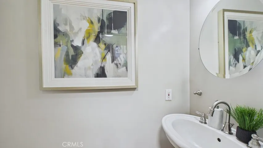 Powder room situated near the butler's pantry, adjacent to the laundry area and the side entrance leading to the backyard, with access to the staircase connecting to the bedroom above the garage.
