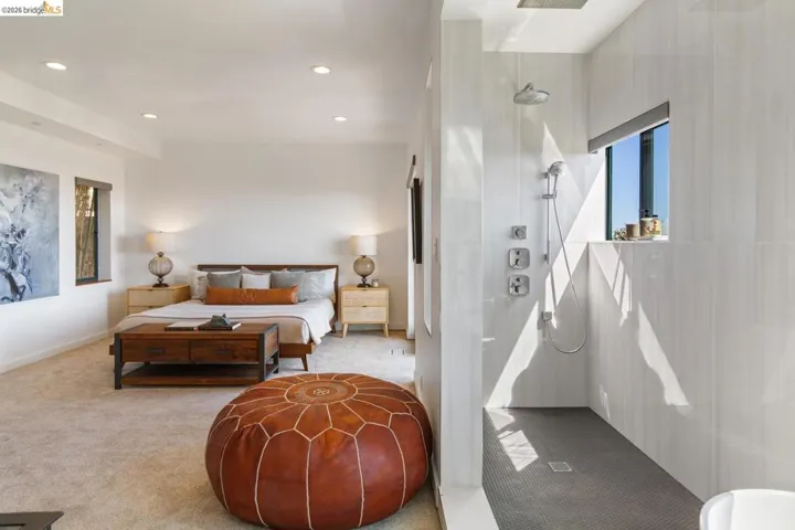 Spacious room with a walk-in shower featuring a rain showerhead, handheld shower, and light-toned tile walls