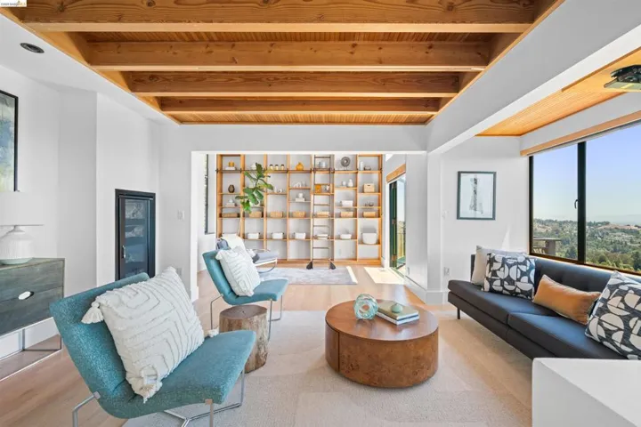 Living area featuring an exposed wood beam ceiling and large picture windows