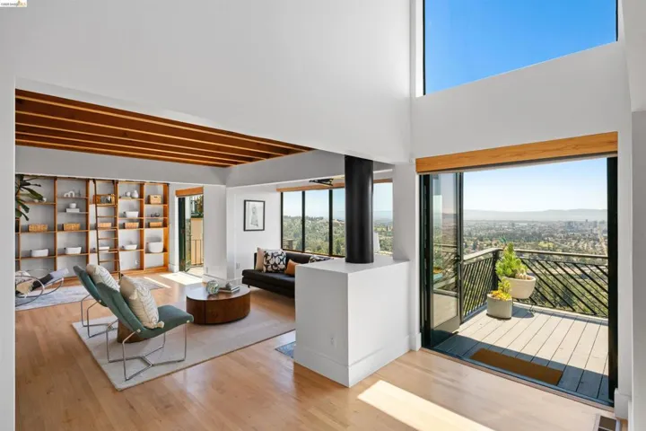 Open-concept living space featuring high ceilings, light wood-finish flooring, and a built-in shelving unit