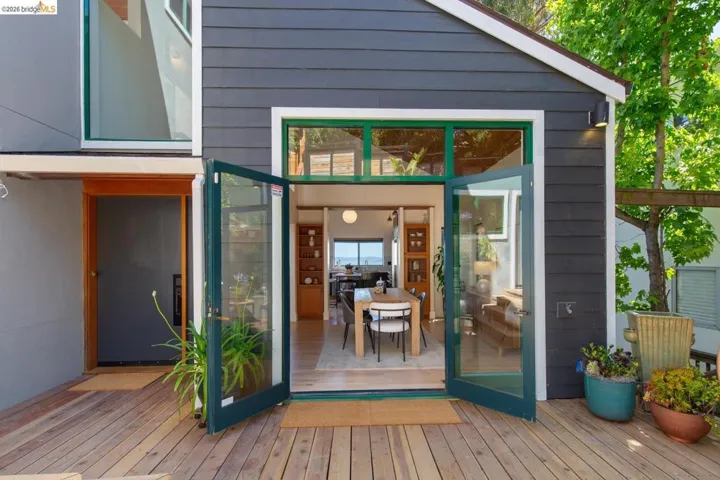Expansive wood-finish deck with direct access to interior dining area through open French doors