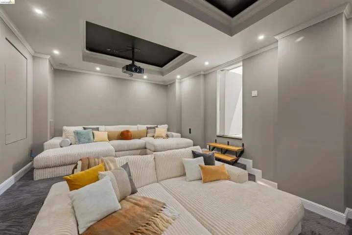 Dedicated media room featuring tiered seating and a ceiling-mounted projector