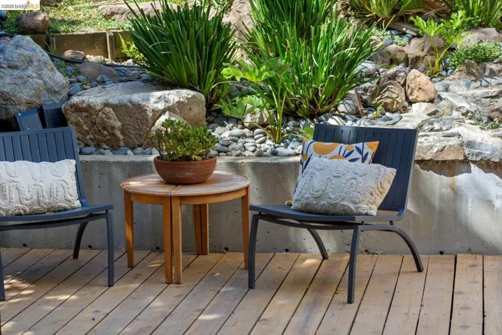 Wood-finish deck with a stone and foliage landscape border