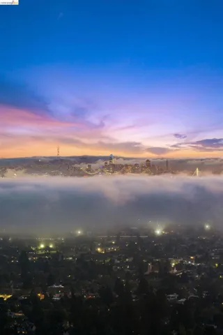 Urban landscape featuring city lights, a prominent skyline, and an expansive sky