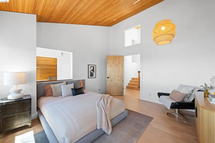 Vaulted wood-paneled ceiling accenting a spacious interior with light wood-finish flooring