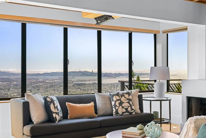 Floor-to-ceiling windows frame a panoramic cityscape and distant water