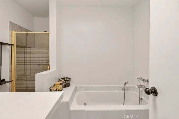 Full bath with soaking tub and glass shower enclosure.
