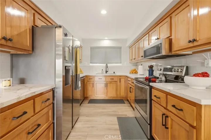 Stainless steel appliances and custom cabinetry throughout.