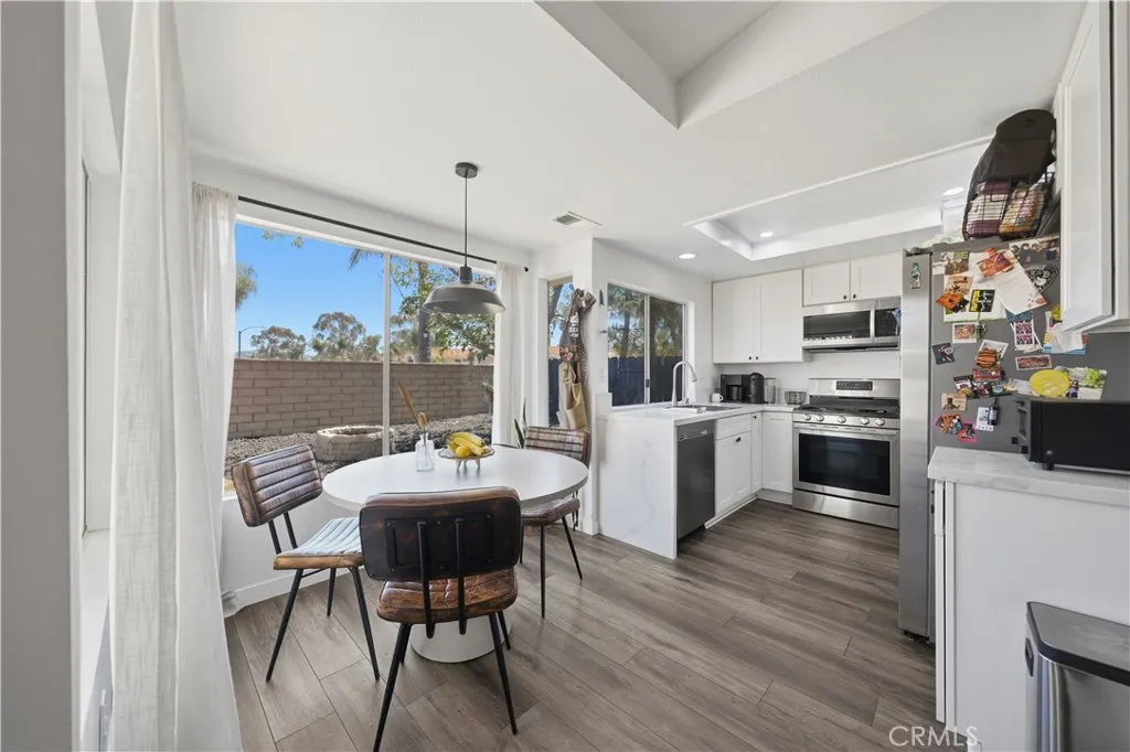 The bright kitchen features ample natural light, a cozy dining nook, and large windows that overlook the backyard.