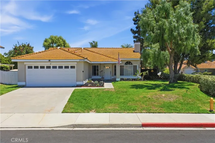 A well-maintained single-story home situated on a desirable corner lot, featuring a spacious front yard, mature trees, and inviting curb appeal in a peaceful neighborhood setting.