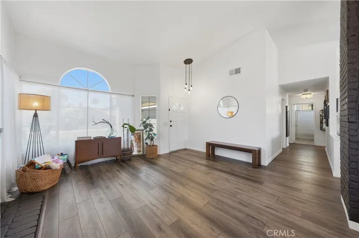 The welcoming entry opens to a bright, airy living space and a central hallway that seamlessly connects the home's living areas and private bedrooms.