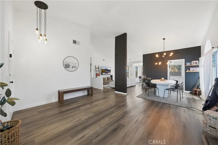 An open-concept living and dining area showcases vaulted ceilings, modern finishes, and an abundance of natural light.