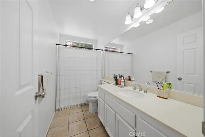 A full guest bathroom features a spacious vanity, ample counter space, and a shower-tub combination.