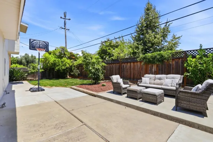 Private backyard featuring an expansive patio, lush lawn, and inviting outdoor seating area.