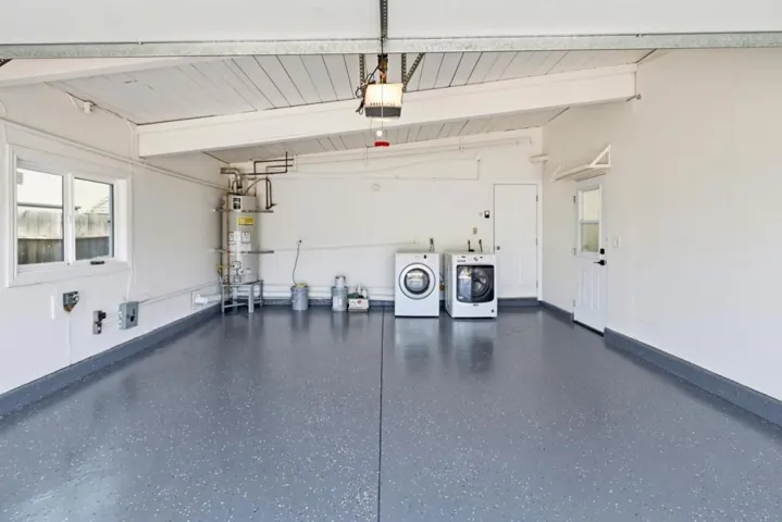 Spacious two-car garage with epoxy flooring, laundry area, and ample room for storage and projects.