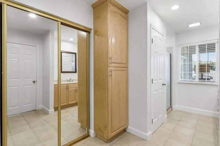 Functional primary bath layout with linen storage, dual closets, and convenient access to the vanity