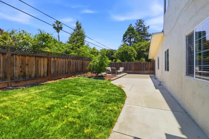 Fenced backyard offering a combination of green space, hardscaping, and multiple areas to relax.