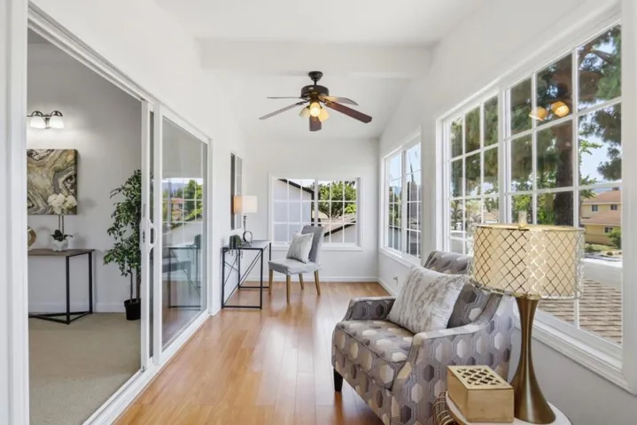 Bright and inviting sunroom with expansive windows, and seamless access to the adjacent living space