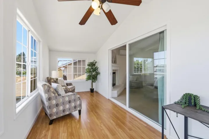 Bright and inviting sunroom with expansive windows, and seamless access to the adjacent living space